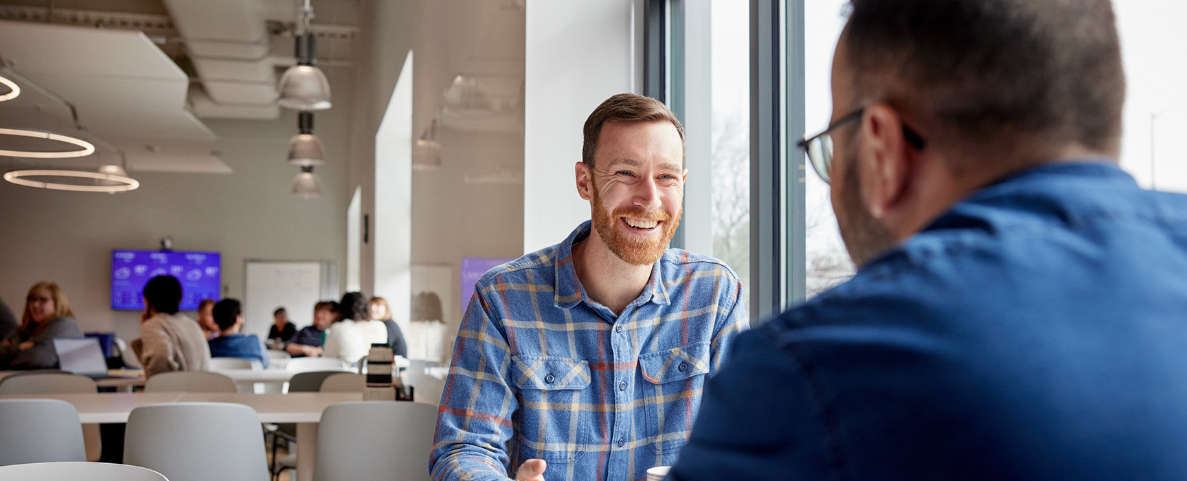 An employee from Invaio talking to another employee