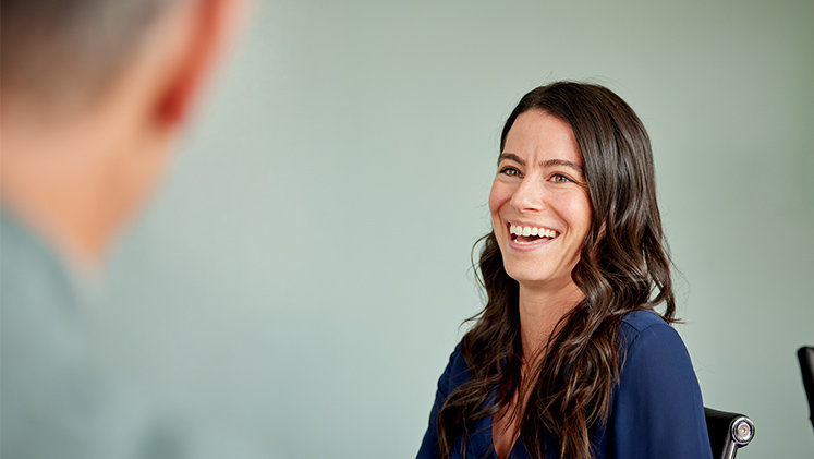 A person laughing in a meeting room