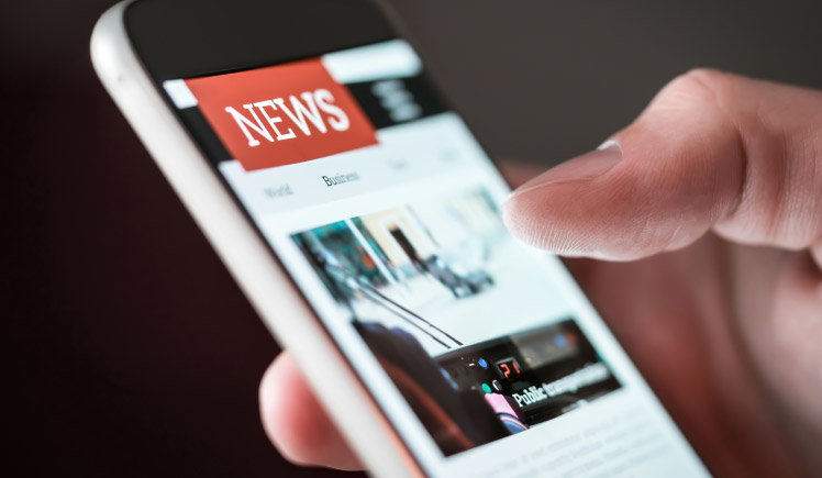 A hand scrolling through news